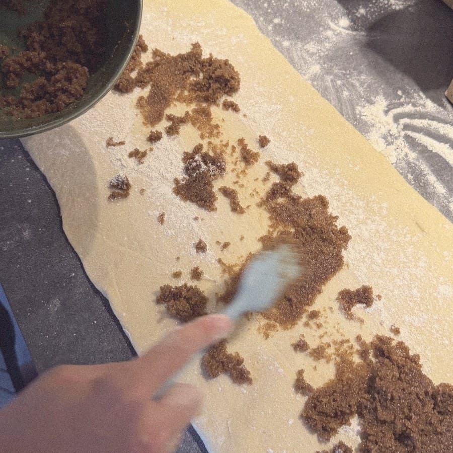 Cinnamon sugar going onto the dough