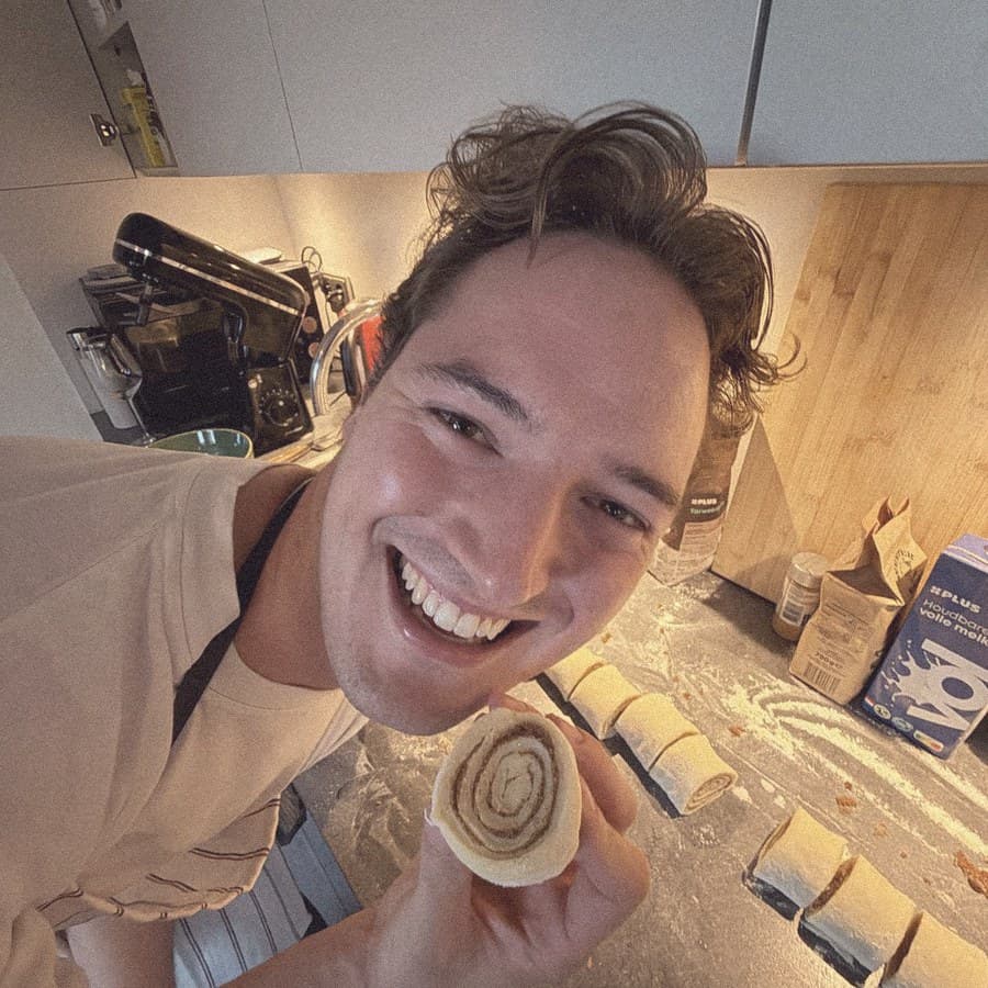 Zach in the kitchen, holding up a roll