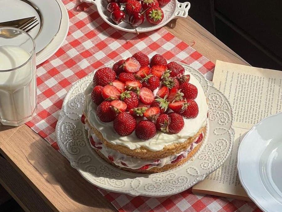 A strawberry cake on a checked cloth